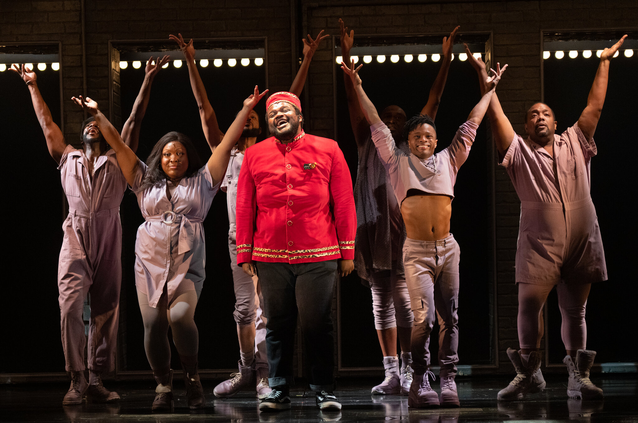 A group of performers with their hands up in cheer