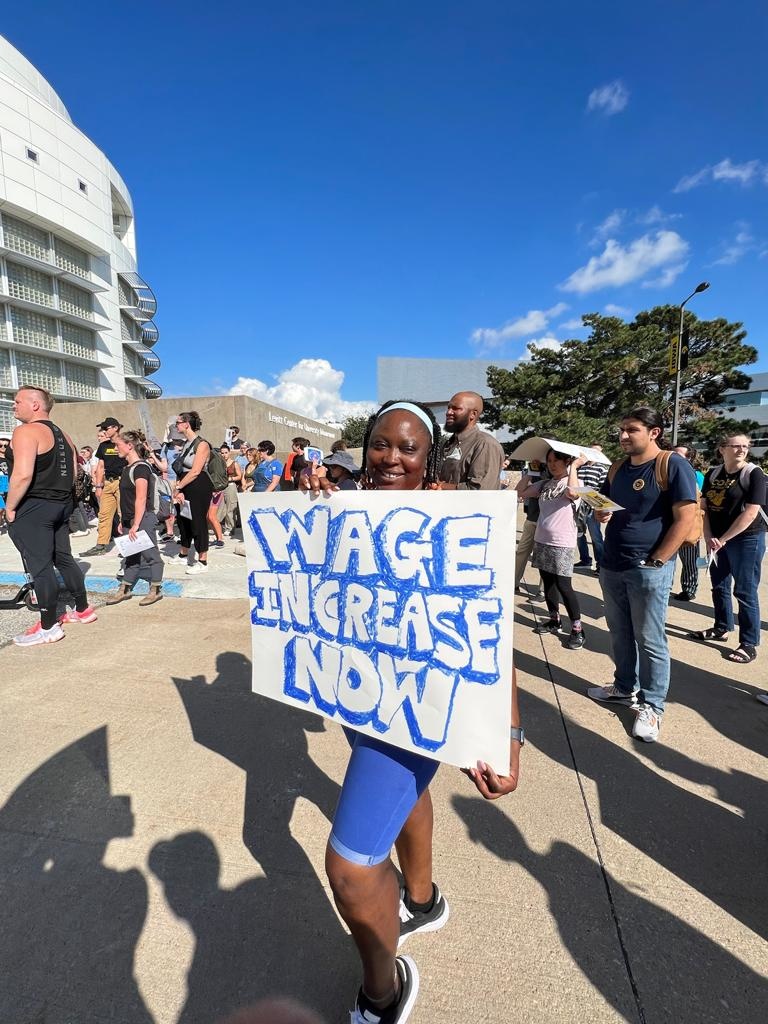 Woman holding a poster for wage equality