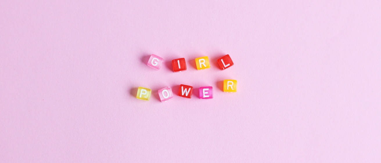 Pink, yellow and red blocks that spell "girl power" on a pink background.