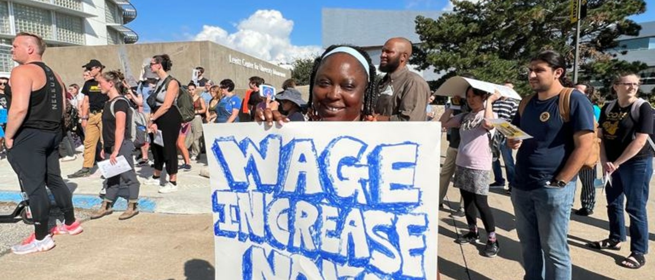 Woman holding a poster for wage equality
